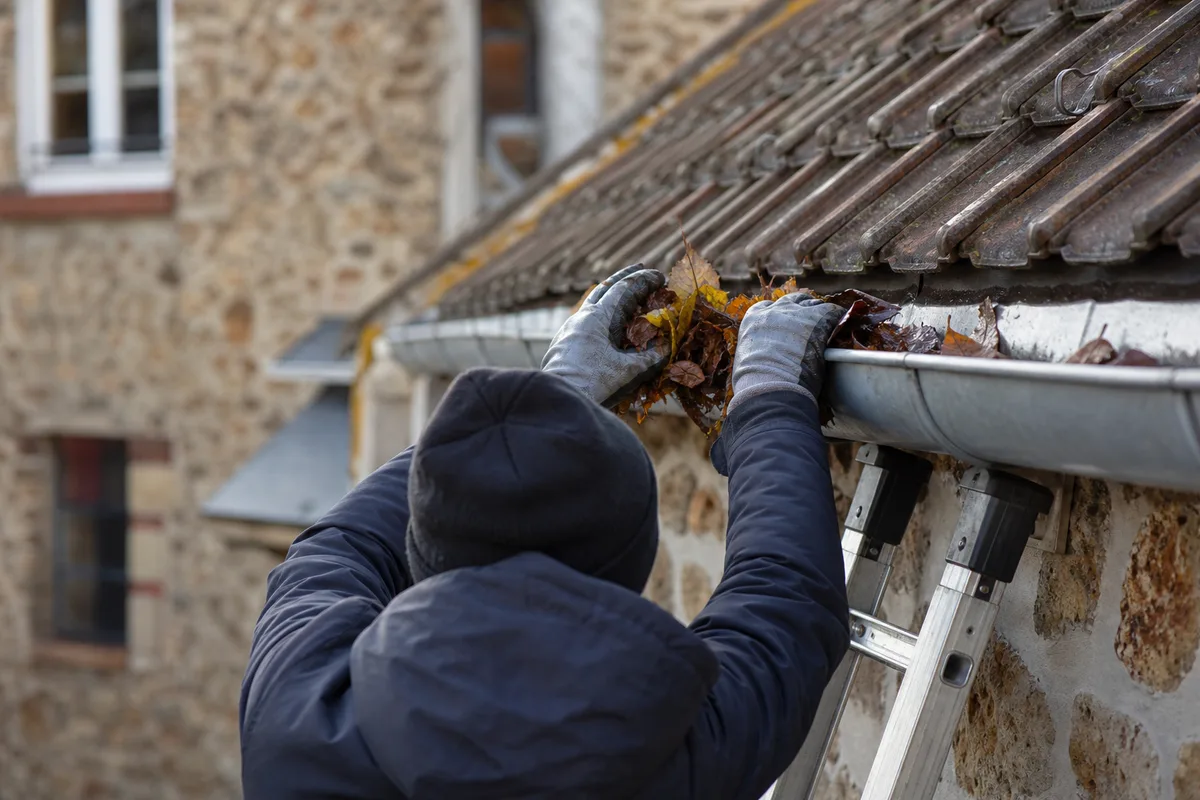 Gouttière en zinc et façade en meulière en cours d’entretien sur un pavillon francilien