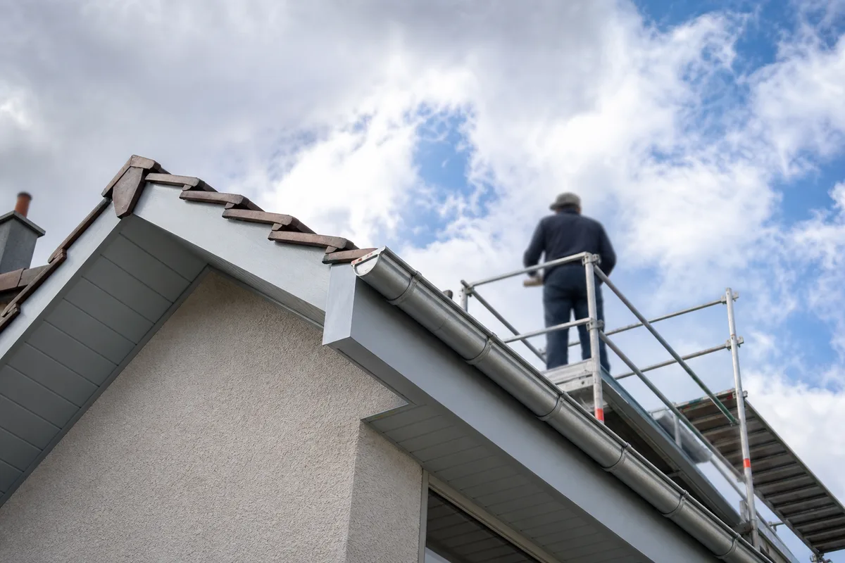 Planches de rive et débord de toit repeints sur un pavillon francilien, échafaudage en place